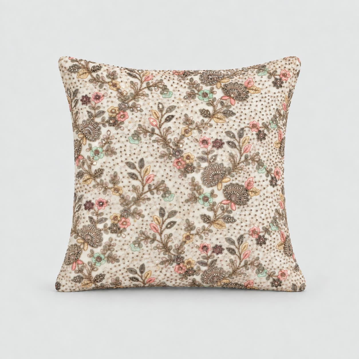 Cream cushion cover covered in a trailing chintz floral of brown seedheads, dusty pink and mustard blooms with a beaded scatter between the stems, on a pale grey background