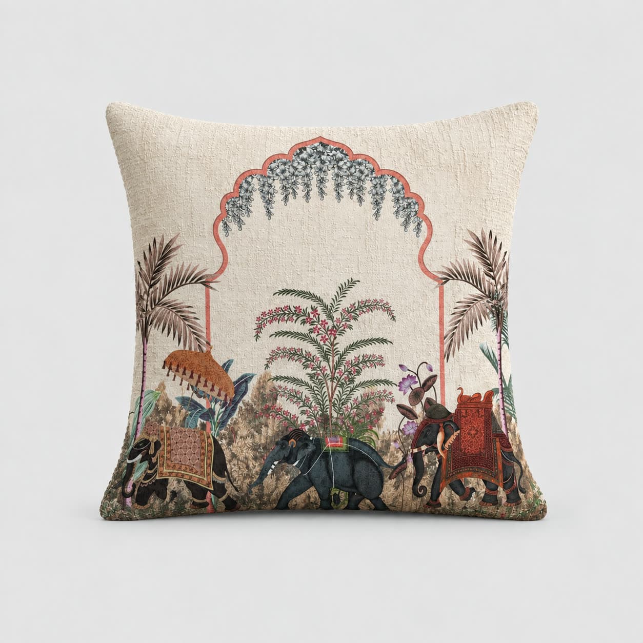Cream cotton-linen cushion cover printed with a coral scalloped arch, blue wisteria, date palms and a procession of decorated elephants, on a pale grey background